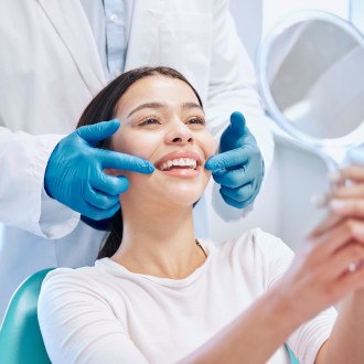 a patient with braces brushing their teeth