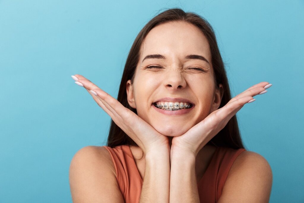 Closeup of woman with dental braces excitedly smiling